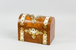 A Victorian walnut dome topped casket shaped tea caddy with Gothic style brass embellishments,