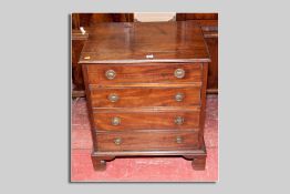 A compact late 19th Century mahogany four drawer chest with brass ring handles and bracket style