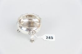 A Georgian silver circular salt with feather edged rim and three shell and hoof supports, 2.4 ozs,
