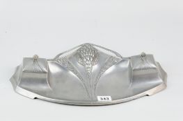An Art Nouveau pewter inkstand of stylized form with central embossed fruit and floral decoration