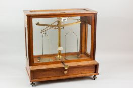 A set of brass L Oertling of London laboratory scales in a glass and mahogany case with single