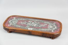 A 19th Century walnut beadwork decorated footstool with glass protector, raised on turned wooden