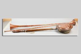 An antique copper warming pan with patterned lid and turned handle and two copper and brass post