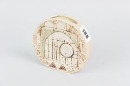 A Troika pottery wheel vase, sand-coloured with gloss finish, each side decorated with relief and