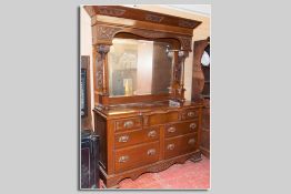 A late Victorian mahogany mirror backed sideboard having carved panels surrounding the central