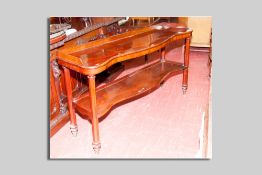 A fine mahogany serpentine front two tier serving waiter, the top having a narrow railback to a