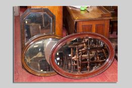Two Victorian oval bevelled edge mirrors and an oak framed bevelled edge mirror, various sizes