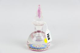 A Crieff Scotland Perthshire glass bottle paperweight, ruby base with millefiori cane decoration,