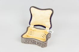 A square silk covered lidded ring and trinket box having concave pierced silver walls featuring