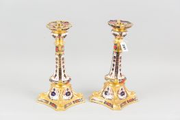A pair of Royal Crown Derby old Imari candle holders, each on a square shaped base with shaped