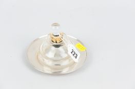 An heavy glass inkwell on a circular silver dish, 1.3ozs, Sheffield 1922