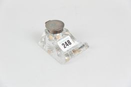 A single bottle glass inkwell with star cut base and silver collar and hinged lid, marks for