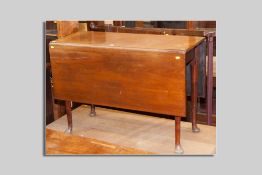 A Georgian mahogany drop leaf dining table with tapered turned supports and pad feet,