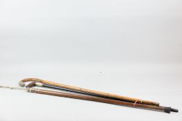 Three walking canes, an ebony horn-handled example with silver mounts, a faux bamboo example with