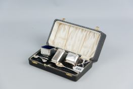 A cased three piece silver condiment set, each piece of plain square form with spoons, 4 ozs,