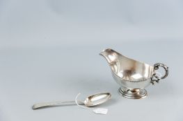 An oval based silver sauce boat of plain form with gadrooned rim, 5.6 ozs, Sheffield 1934 and a