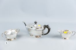 A three piece silver tea service, each piece of oval plain panelled form on shallow pedestal