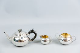 A three piece silver tea service, bullet shaped, the teapot with a composition handle, a twin