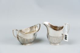 A silver twin handled sugar basin of reeded form with matching cream jug, 7.2 ozs, London 1903