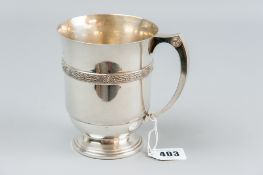 A heavy silver mug on a lined pedestal base and having a Celtic type decorative band, 14.9 ozs,