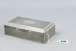 An oblong engine turned silver bound cigarette box with a stepped lid having a Grecian Key style
