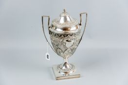 A fine and important silver racing trophy standing on a square base with shallow column and the body