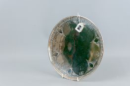 A large circular sterling silver dish having a pierced border with bright cut classical style