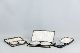 A cased pair of cut glass butter dishes with a pair of silver knives, Birmingham 1940, a cased cut