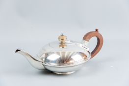 A plain silver bullet shaped teapot on a short pedestal with composition handle and knop,