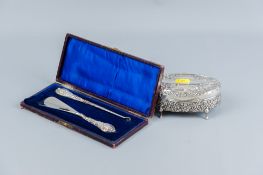 An oval silver ring box with scrolled and floral all over decoration and with green velvet lined