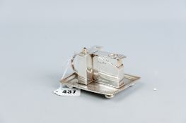 A near square silver smoking tray with ring handle having a cigarette guillotine and wick burner,