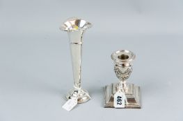 A short stemmed silver candleholder having a stepped beadwork base and a classical style garlanded