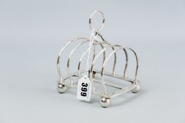 A four section silver toast rack, each rail of turned form and on corner ball supports, 8.9 ozs,