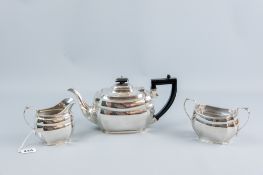 A three piece silver tea service of oval plain form with concave corners, the teapot having a