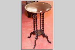 A circular tray top mahogany side table with four barley twist supports and lower central tray on