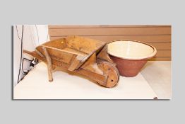 A small pine wheelbarrow and a cream glazed circular egg crock (hairline crack)