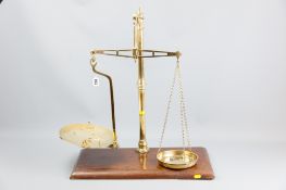 A set of brass provision scales on an oblong mahogany base