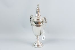 A silver twin handled circular based trophy vase of plain panelled form with garlanded and curved