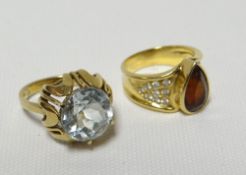 A modern 14k yellow gold zircon ring together with another modern dress ring