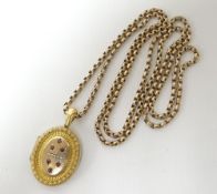 A long muff chain, believed 9ct (hallmark unclear) attached to a believed gold Victorian oval