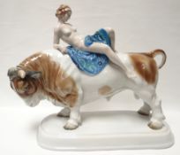 A Continental porcelain model of a reclining maiden upon a standing bull, all on an oval base, 15.