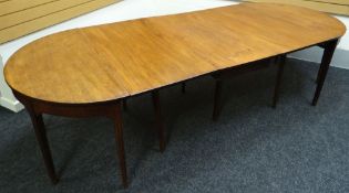 A Georgian d-end mahogany dining table with three extending leaves and on reeded tapered supports,