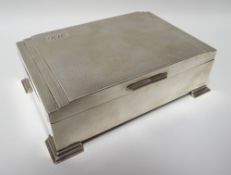 A wood-lined Art Deco-style machine-turned silver cigarette box, on stepped corner supports and with