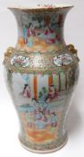 A Canton famille-rose baluster vase with lion-ring handles and decorated with typical panelled