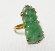 A carved jade ring set in unmarked yellow metal