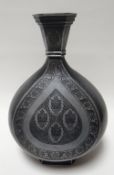 An unusual Persian decorated metallic vase, of teardrop form with faceted foot and narrow tapering