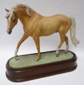 A Royal Worcester model of a 'Palomino Stallion', No.611, dated 1971, on an oval base with wooden