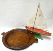 A primitive wooden dish with twin handles, 20ins diam (51cms); together with a painted wooden pond