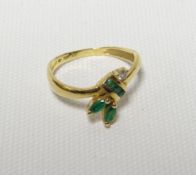 An emerald and diamond floral ring