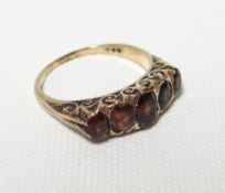 A 9ct yellow gold ring set with a row of five graduated garnets, 4.2gms